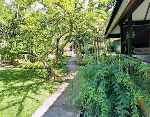 A garden pathway leading to a building with a covered outdoor area.