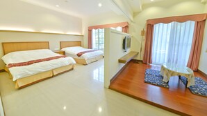A hotel room with three beds, a television, a small table, and a window with curtains. - Malia Homestay (Hualien City)