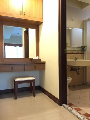 Une salle de bain avec un meuble-lavabo en bois, un miroir, un évier et des toilettes.