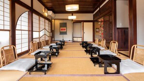 Una habitación tradicional japonesa con suelo de tatami, mobiliario de madera y puertas correderas.