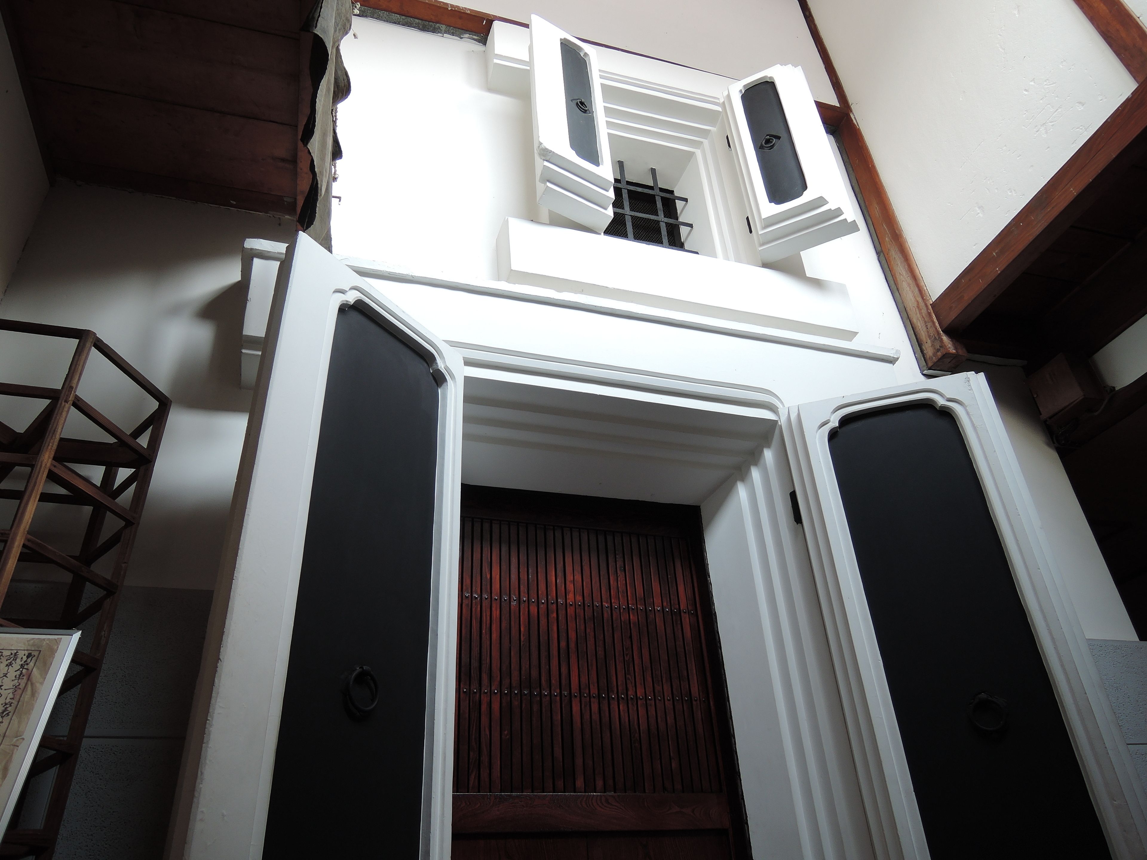 A traditional Japanese-style entrance with a wooden door and a small window.