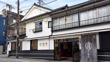 Traditional Japanese building with a two-story structure, featuring a storefront and balcony.
