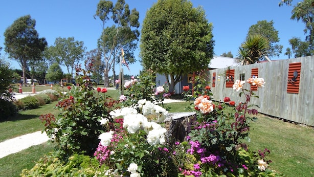 Un jardin agrémenté de différentes sortes de fleurs et entouré d’une clôture en bois.