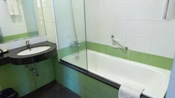 A bathroom with a sink, mirror, and bathtub.