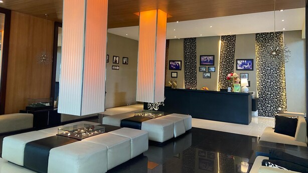 Un vestíbulo moderno con mostrador de recepción, zona de estar y detalles decorativos.