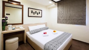 A hotel room with a bed, bedside table, and a large mirror. There is a framed picture on the wall and a window with a textured blind. - Hotel 81 Fuji (Singapore)