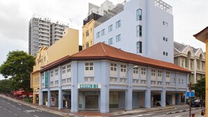 A hotel with a traditional facade, multiple stories, and a red-tiled roof. - Hotel 81 Fuji (Singapore)