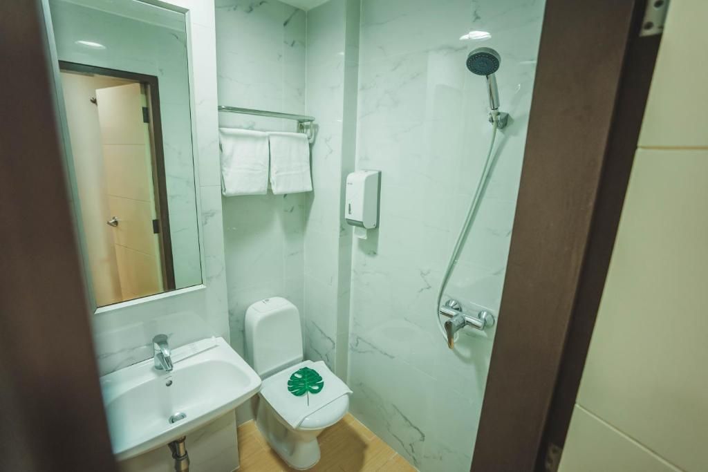 Un baño con lavamanos, inodoro y ducha.
