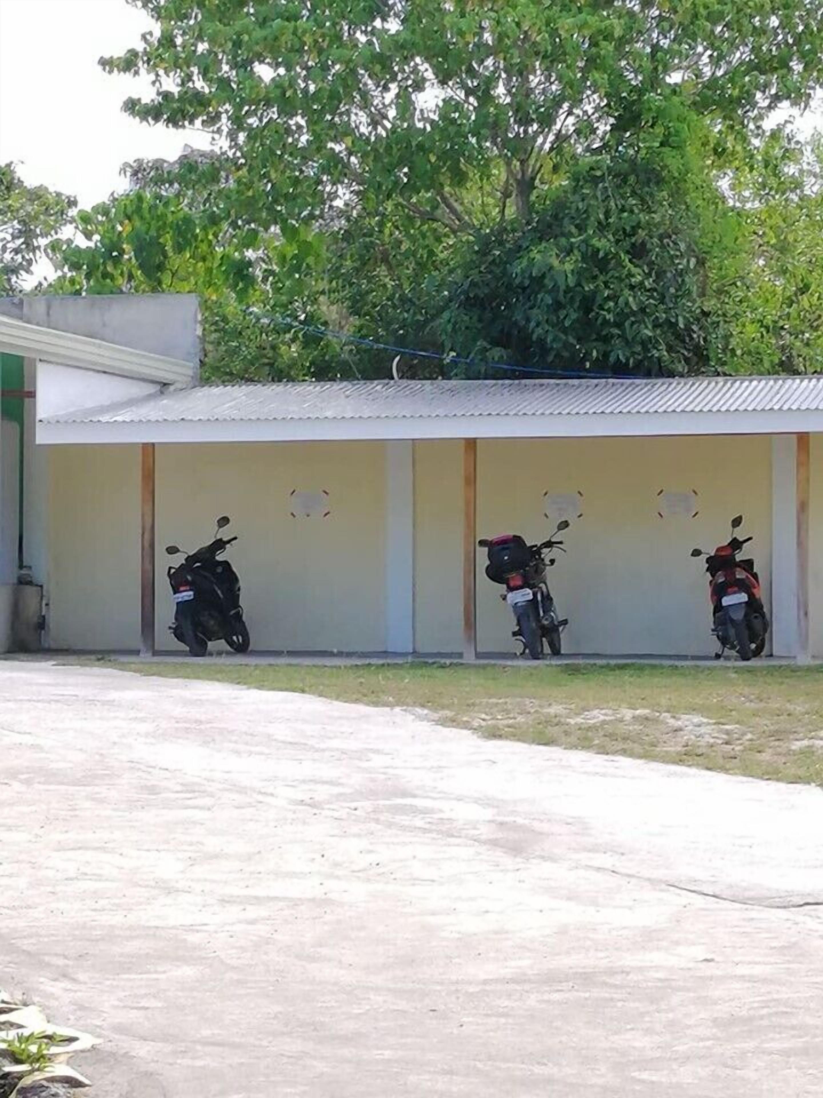 A building with three motorcycles parked in front.
