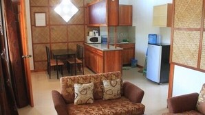 Een knus woongedeelte met een bank, een eettafel en een kitchenette.