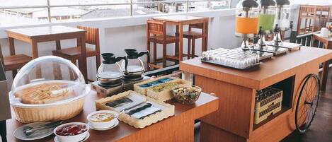 A breakfast bar with various food items and a coffee machine.