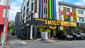 A hotel with a modern facade, vertical colorful stripes, and a sign indicating room rates. - Smile Hotel Cheras Sri Permaisuri (Kuala Lumpur)