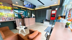 A hotel lobby with a reception desk, a TV screen displaying a room, and seating areas. - Smile Hotel Cheras Sri Permaisuri (Kuala Lumpur)