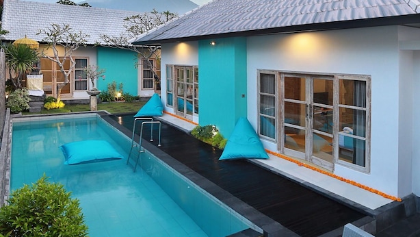 A modern hotel with a swimming pool, outdoor seating, and a mountain view. - Akasa Villa Tulamben (Tulamben)