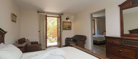 Um quarto com uma cama grande, uma cômoda de madeira, uma cadeira e um quadro na parede.