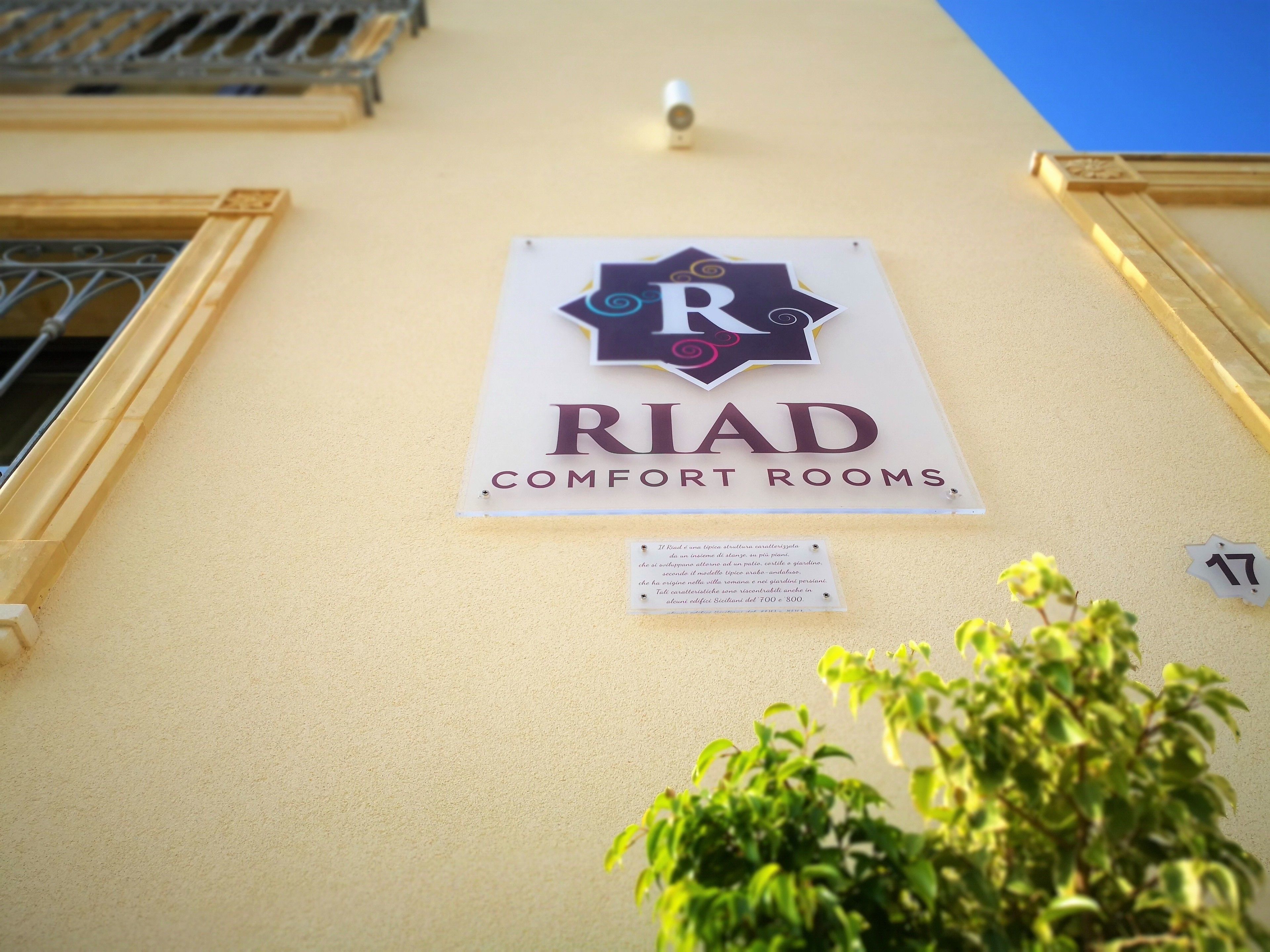 A sign for 'RIAD COMFORT ROOMS' on a building wall.