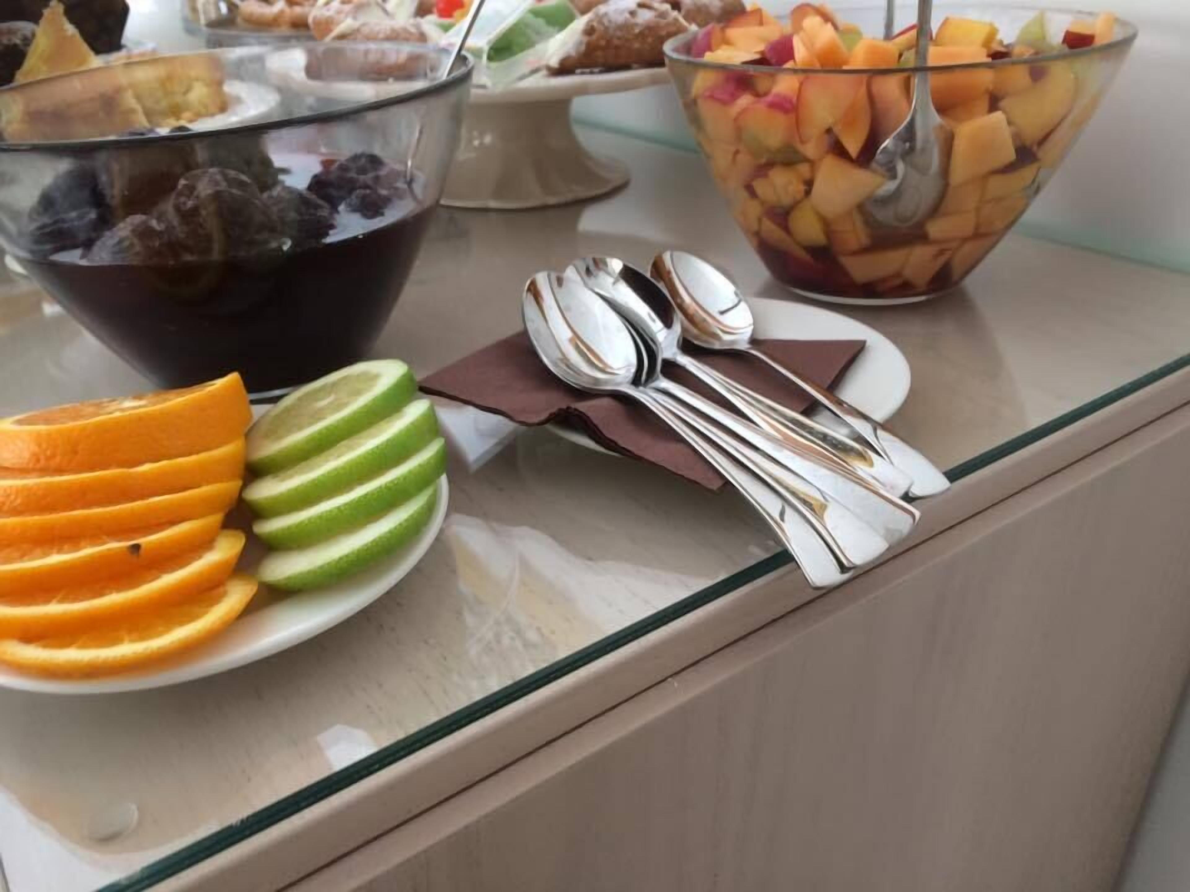 A buffet table with various fruits and desserts.