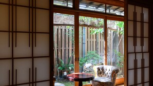 Une pièce de style japonais traditionnel, avec un sol recouvert de tatamis, une table basse et un fauteuil rembourré.
