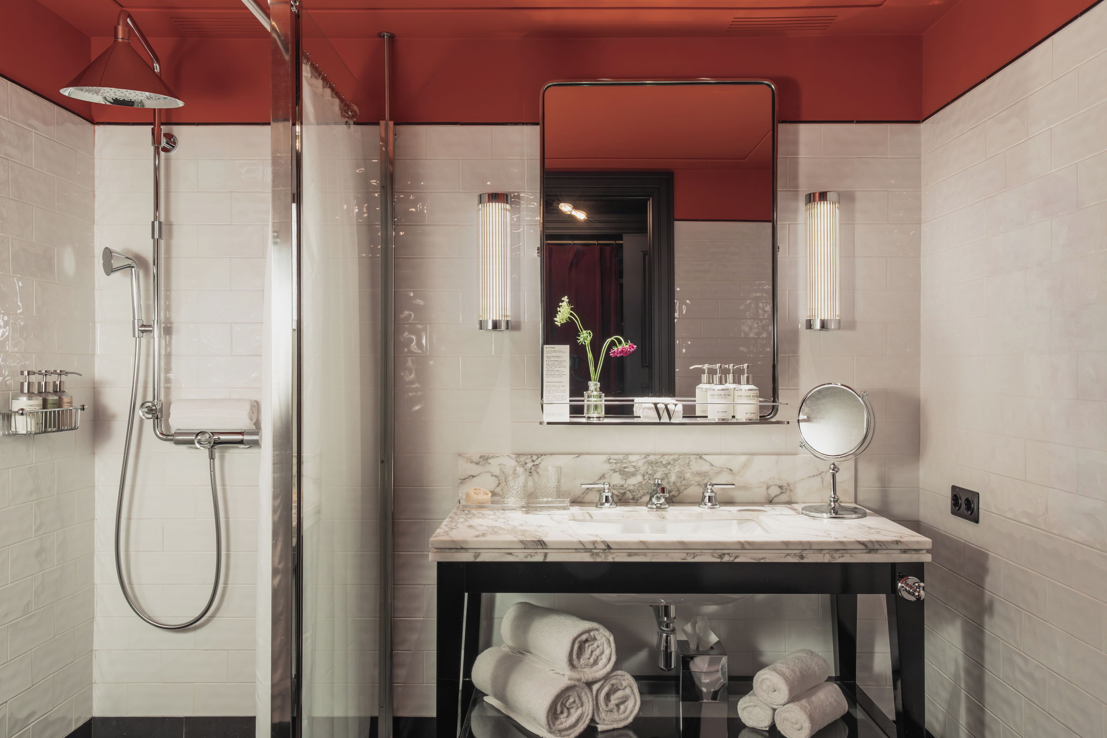 Un baño moderno con ducha, tocador con espejo y encimera de mármol.
