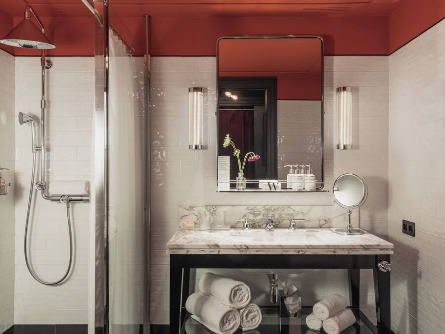 Un baño moderno con ducha, tocador con espejo y encimera de mármol.