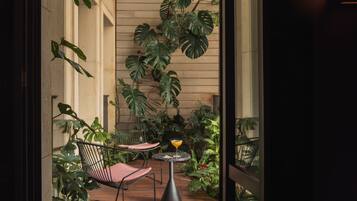 Un espacio al aire libre acogedor con una mesa y sillas, rodeado de exuberantes plantas tropicales.