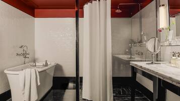 Ein modernes Badezimmer mit einer freistehenden Badewanne, einer Duschkabine aus Glas und einem Waschtisch mit Spiegel.