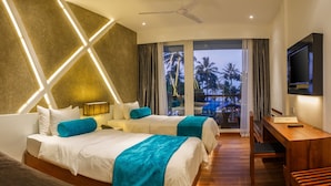 A hotel room with two beds, a TV, a desk, and a balcony with a view of palm trees. - Camelot Beach Hotel (Negombo)
