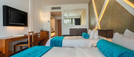 A hotel room with two beds, a desk, a TV, and a large mirror.