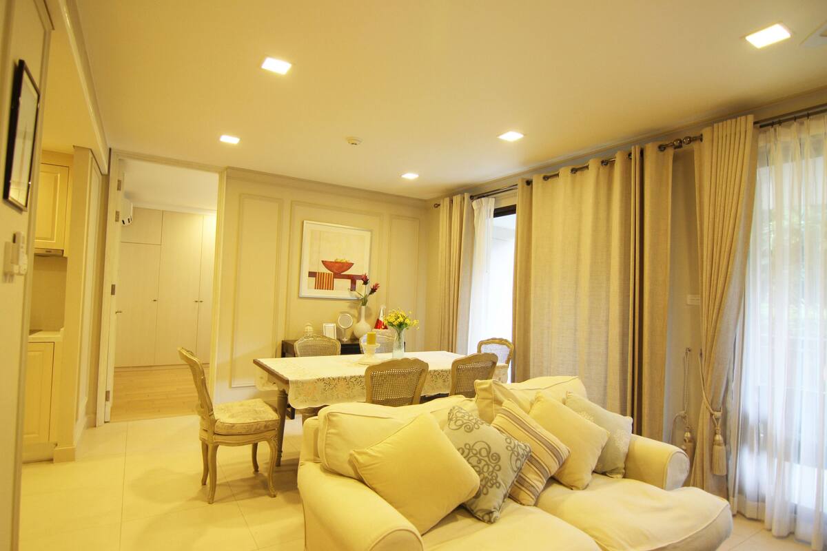 A dining area with a table, chairs, and a sofa.