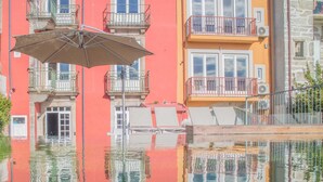 Un edificio con balconi, una piscina e un riflesso nell'acqua.