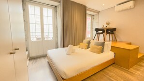 Una camera da letto con un letto, una scrivania, un condizionatore d'aria e vista sull'esterno.