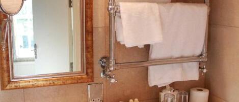 A bathroom with a round sink, a mirror, a towel rack, and a toilet.