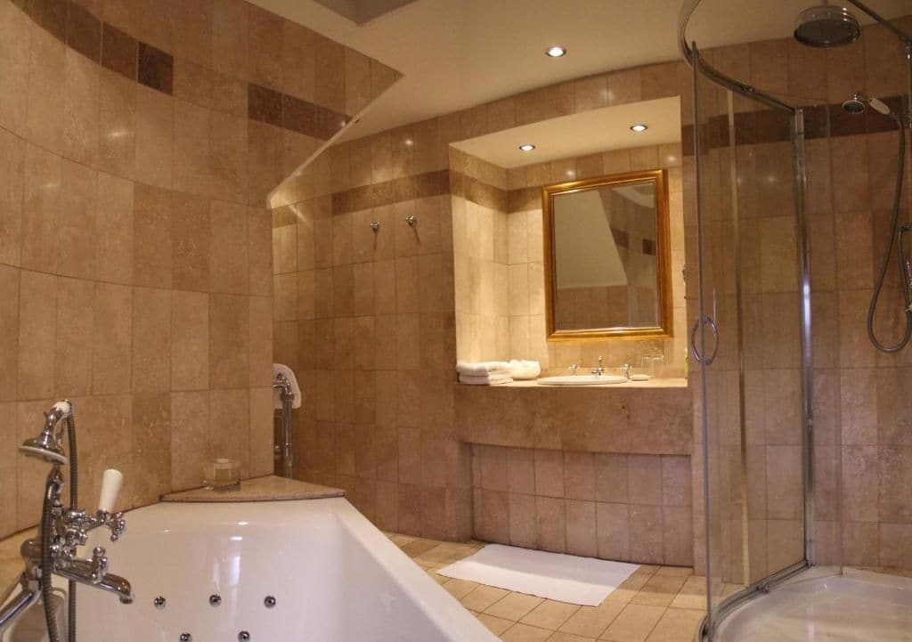 A modern bathroom with a bathtub, a shower, and a vanity with a mirror.