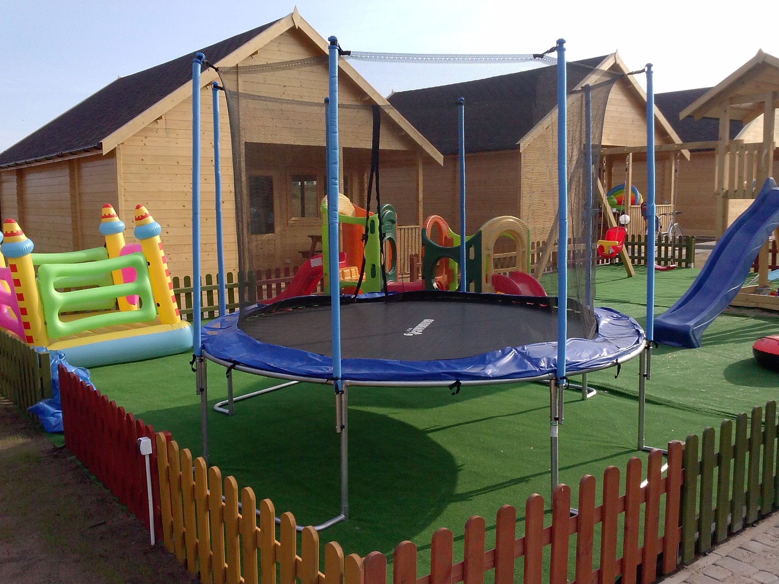 Un’area giochi con trampolino, scivoli e strutture gonfiabili.