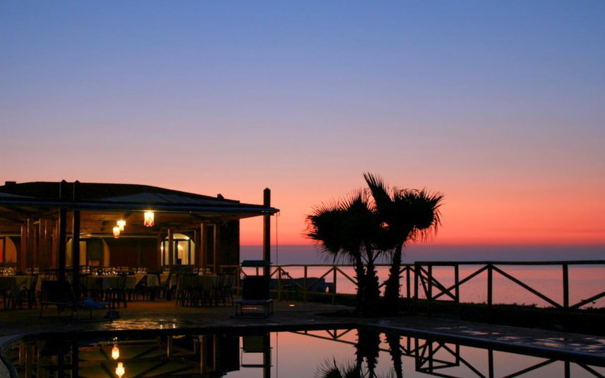 Piscina all'aperto, una piscina a sfioro, lettini