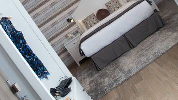 Een moderne slaapkamer met een bed, nachtkastjes, een hanglamp en een nachtkast.