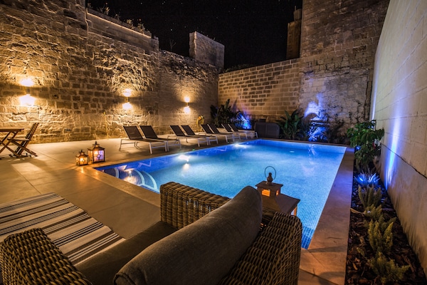 Una piscina al aire libre, sillones reclinables de piscina