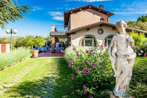 Un bâtiment doté d’un jardin, d’une statue et d’un chemin piétonnier dallé.
