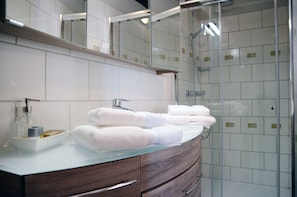 Suite de lujo, vista a la ciudad | Baño | Regadera, amenidades de baño gratuitas, secadora de cabello, batas