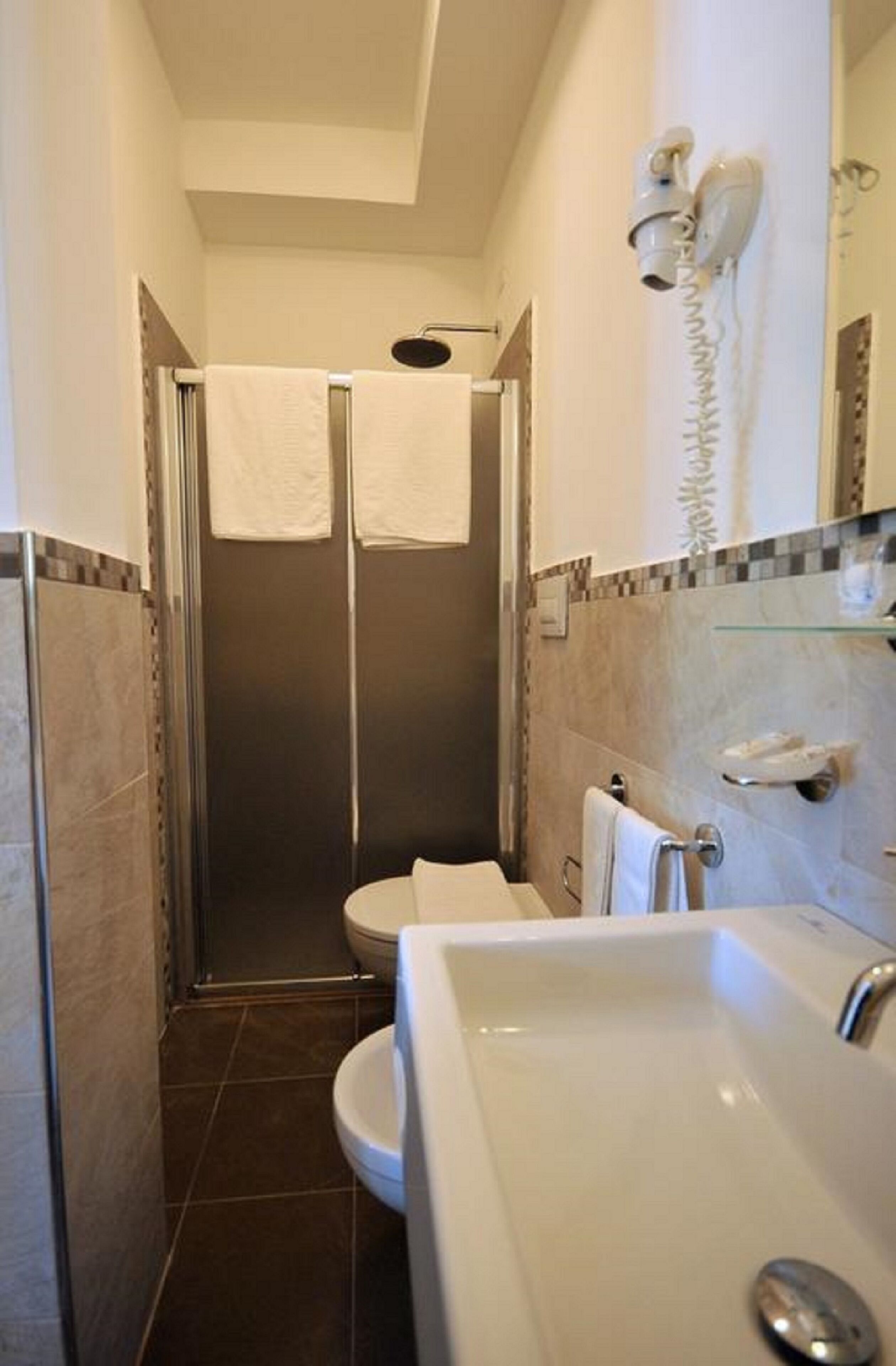 A bathroom with a shower, toilet, and sink.