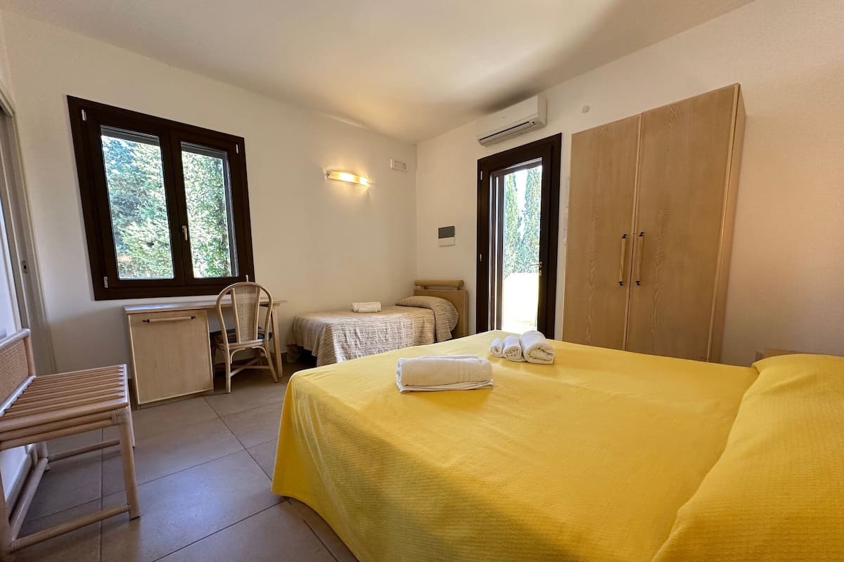 Une chambre à coucher avec un lit, un bureau, une chaise et une armoire.