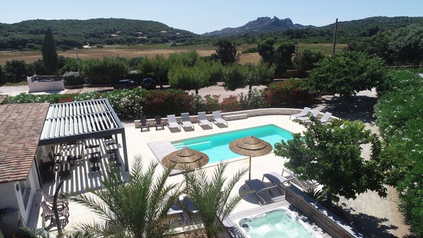 A pool area with lounge chairs, a hot tub, and a pergola. - Hôtel Padolo (Bonifacio)