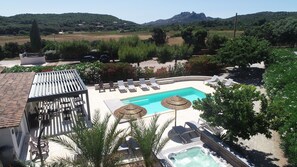 Un espace piscine comprenant des chaises longues, un jacuzzi et une pergola.