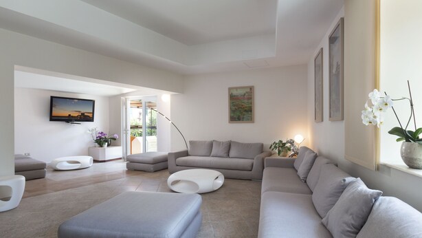 Una sala de estar moderna con un sofá modular, un televisor de pantalla plana y un ventanal con vistas.