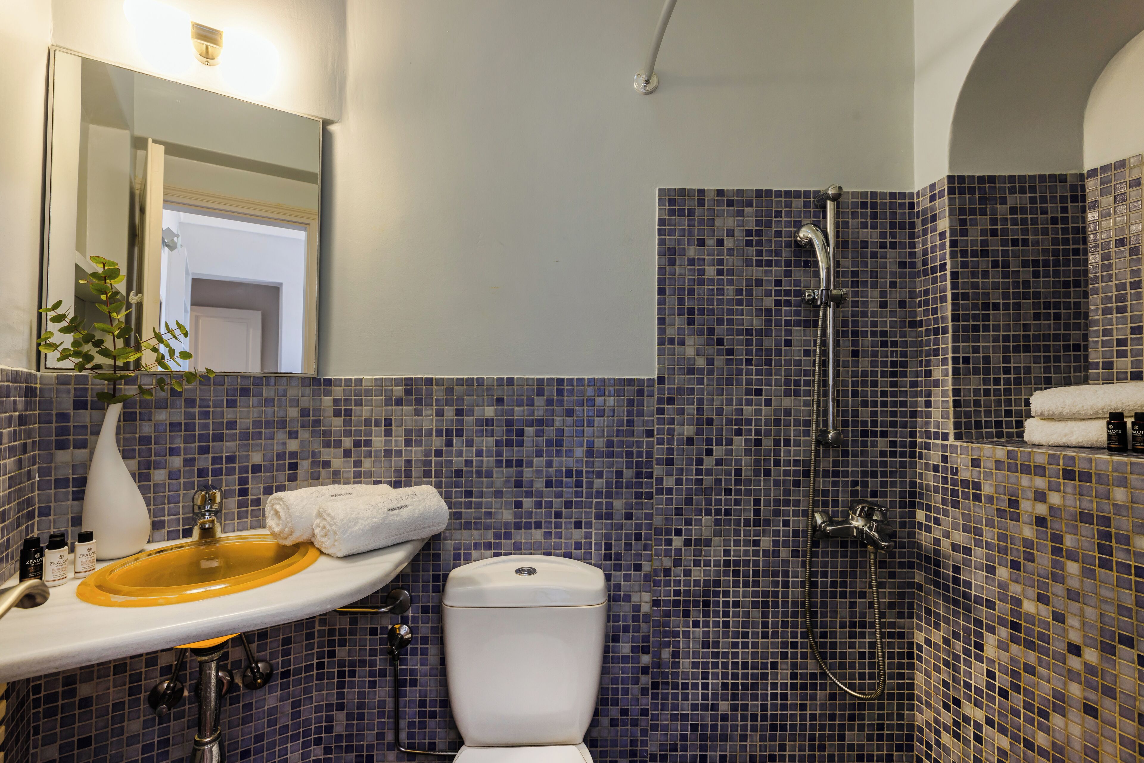 A bathroom with a sink, toilet, and shower.