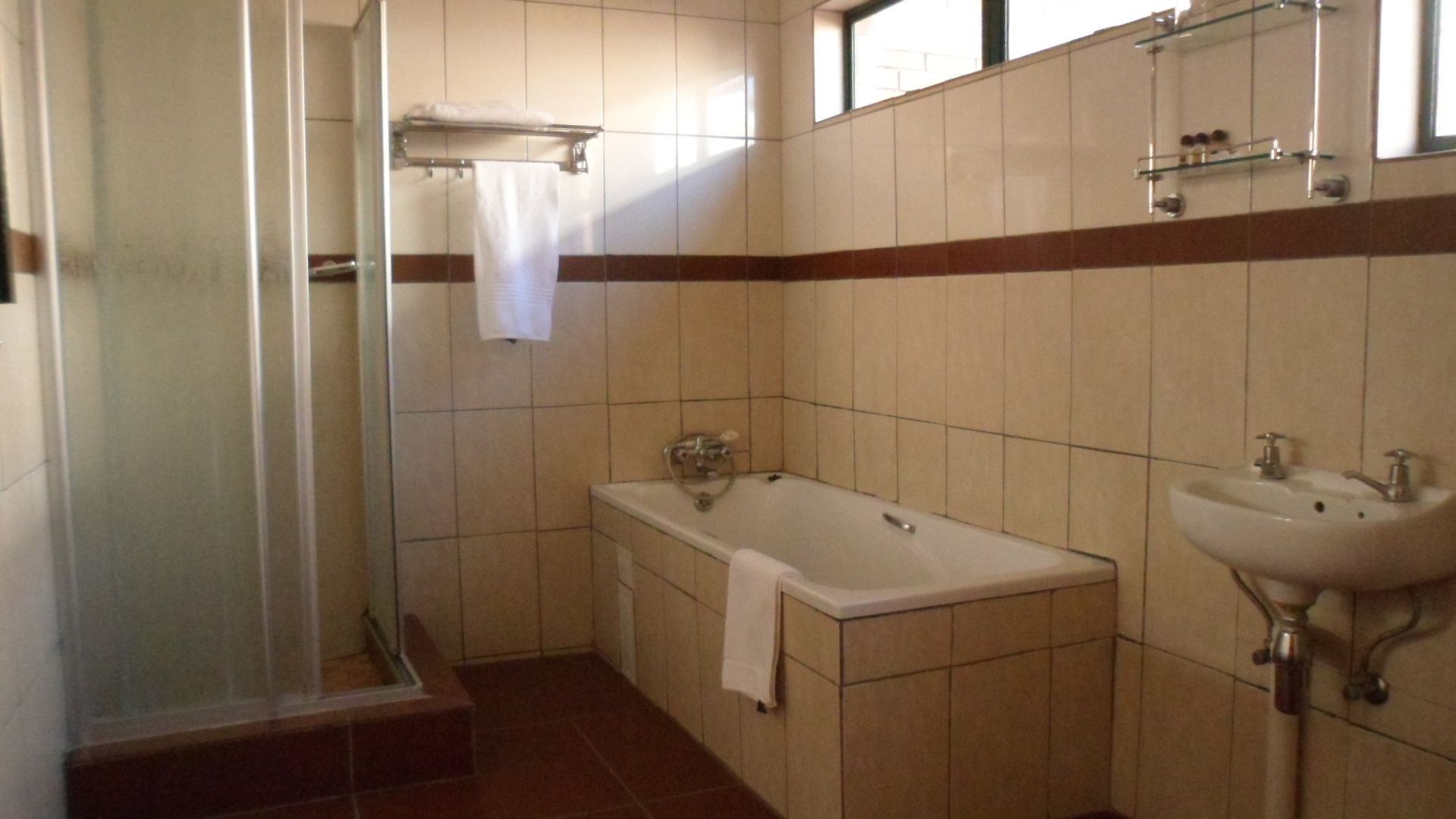 Une salle de bain avec une douche à parois de verre, une baignoire et un lavabo.