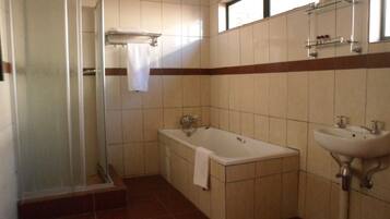 Une salle de bain avec une douche à parois de verre, une baignoire et un lavabo.