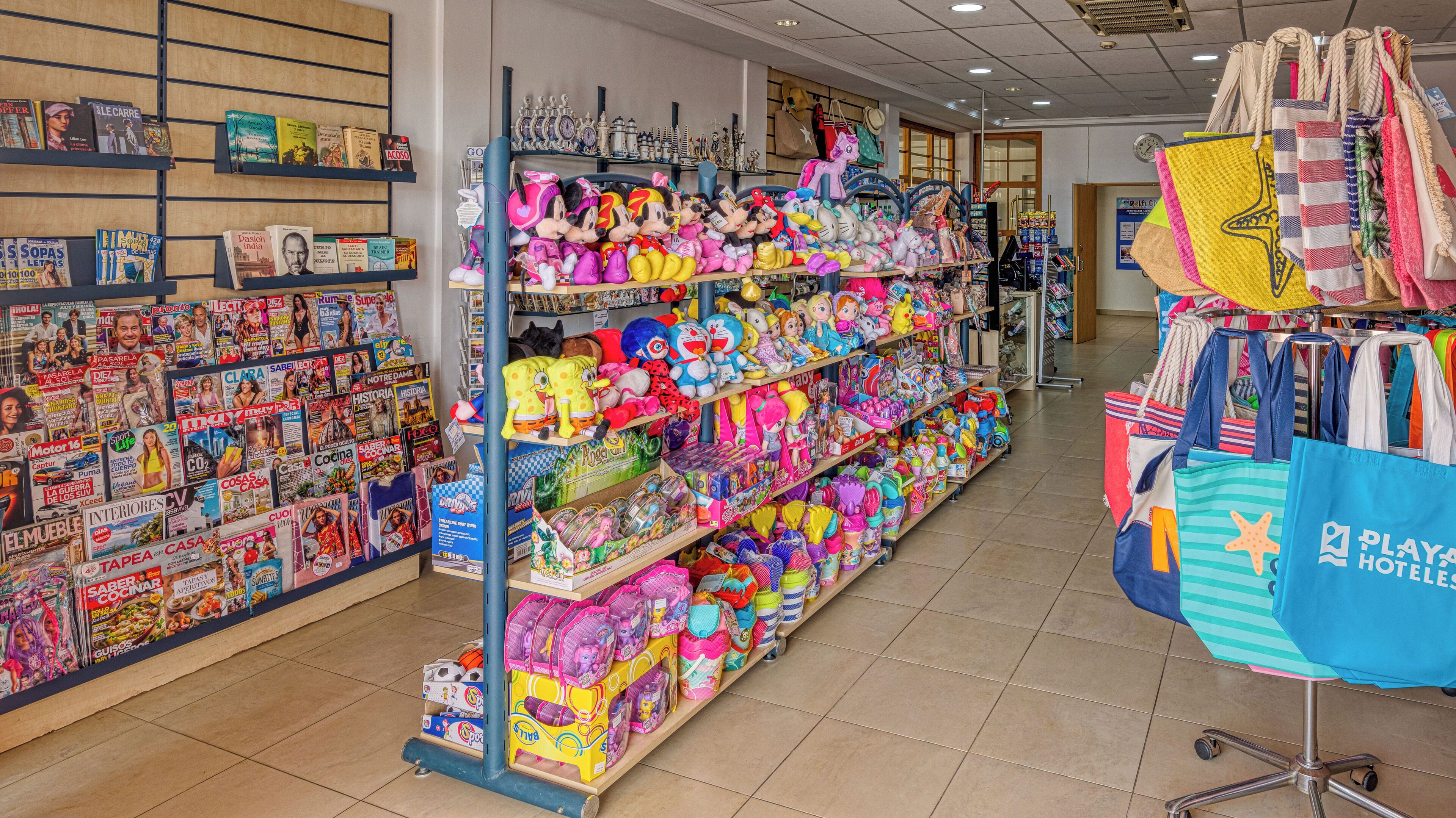 Un magasin avec des étagères remplies de jouets, de livres et de sacs.