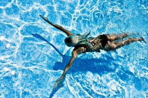 Una persona nadando en una piscina.