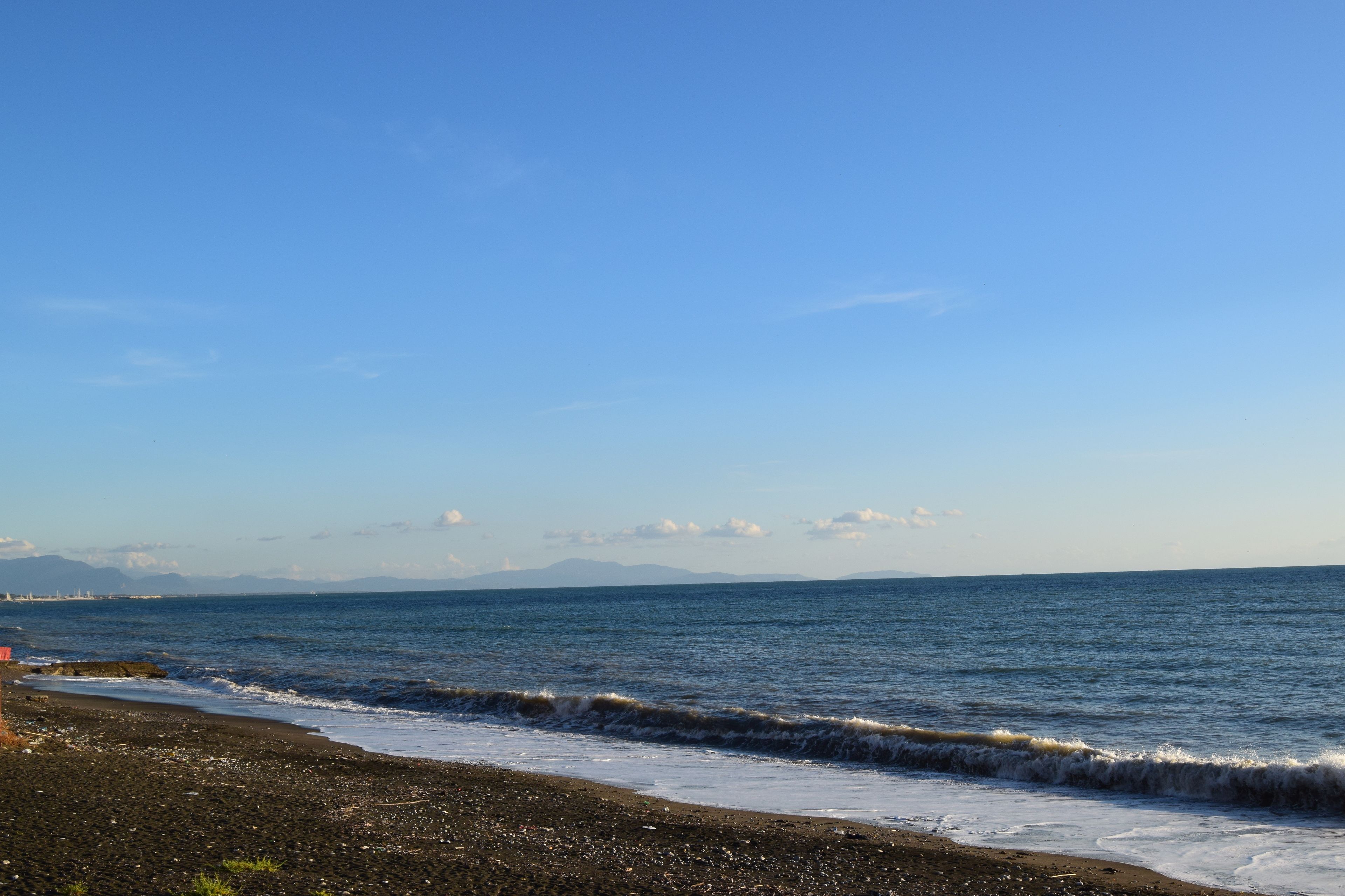 Una playa con costa rocosa y olas.